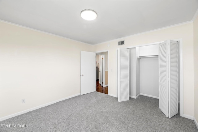 unfurnished bedroom with crown molding, a closet, visible vents, carpet floors, and baseboards