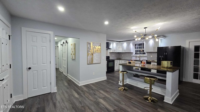 101 Old Vasper Rd, Caryville, TN 37714 - kitchen with wall chimney range hood, dark countertops, white cabinets, dark wood-type flooring, and black appliances