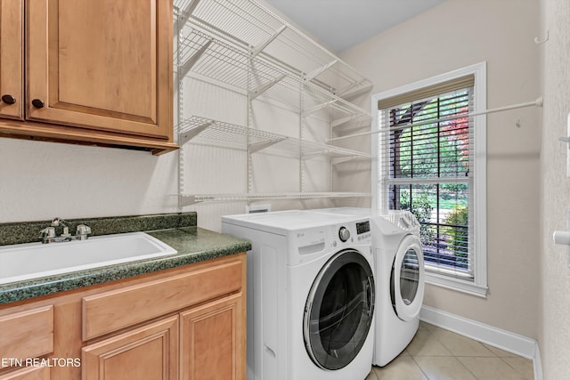 10033 Autumn Valley Ln, Knoxville, TN 37922 - clothes washing area with baseboards, a sink, cabinet space, washing machine and dryer, and light tile patterned flooring