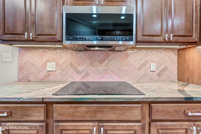 10033 Autumn Valley Ln, Knoxville, TN 37922 - kitchen with stainless steel microwave, decorative backsplash, light stone counters, and stovetop