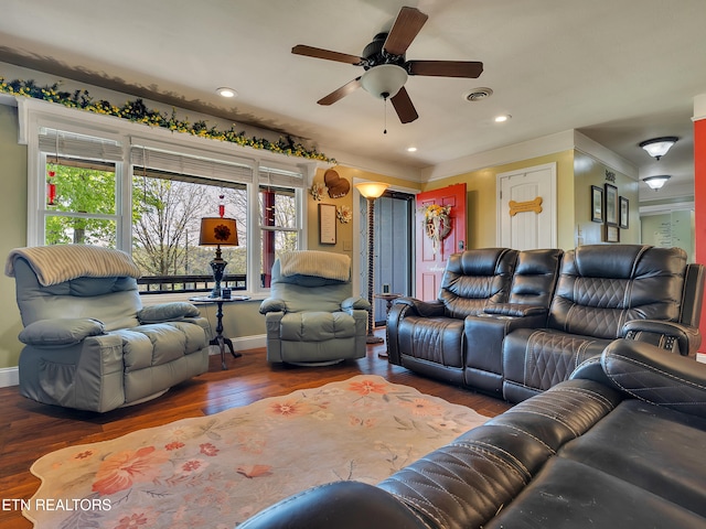 living area featuring ceiling fan, visible vents, baseboards, and wood finished floors
