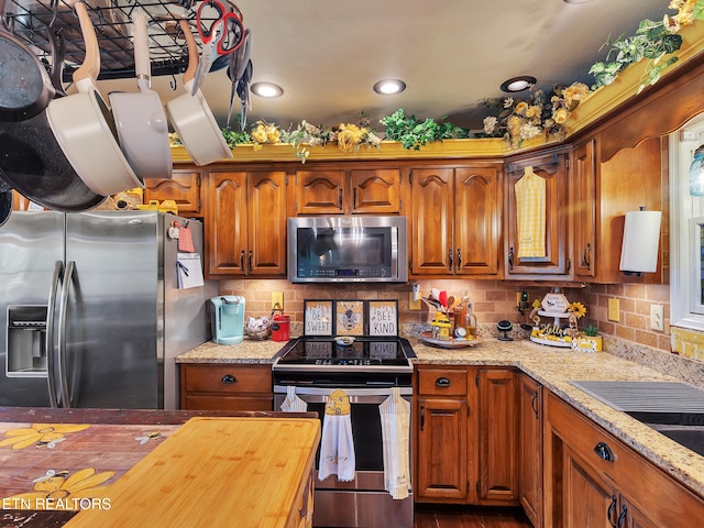 kitchen featuring brown cabinets, decorative backsplash, and appliances with stainless steel finishes