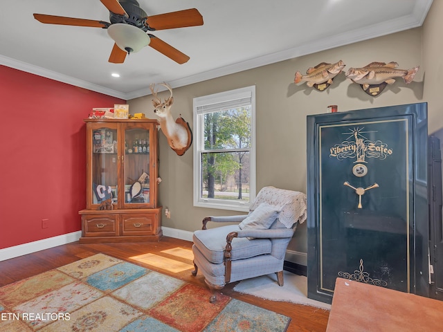 living area with ornamental molding, baseboards, and wood finished floors