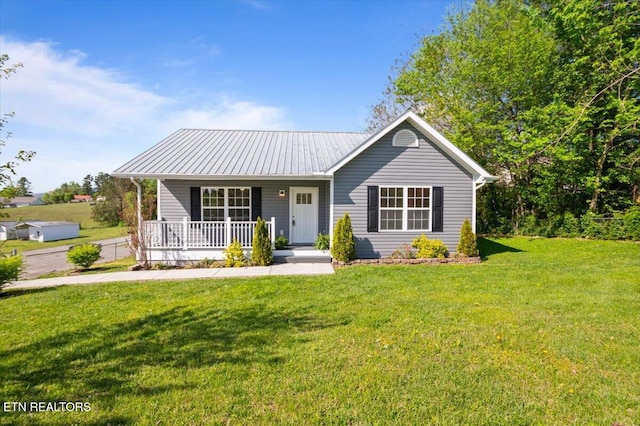 view of front of home featuring a front yard, metal roof, and covered porch