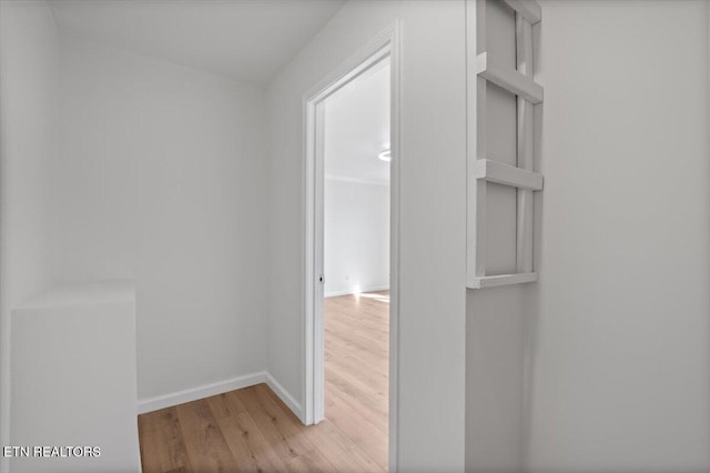 hall with light wood finished floors and baseboards