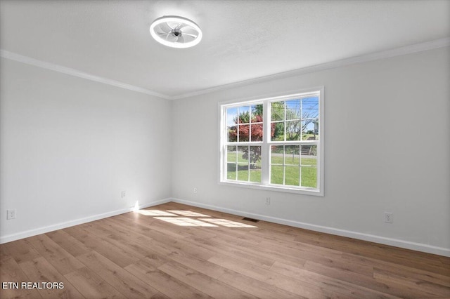 unfurnished room with visible vents, baseboards, crown molding, and wood finished floors