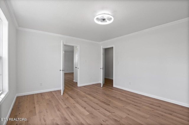 unfurnished bedroom with crown molding, baseboards, and light wood finished floors