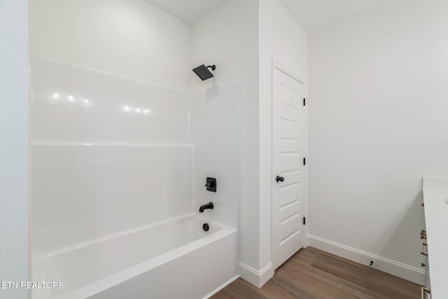 full bathroom with baseboards, tub / shower combination, and wood finished floors