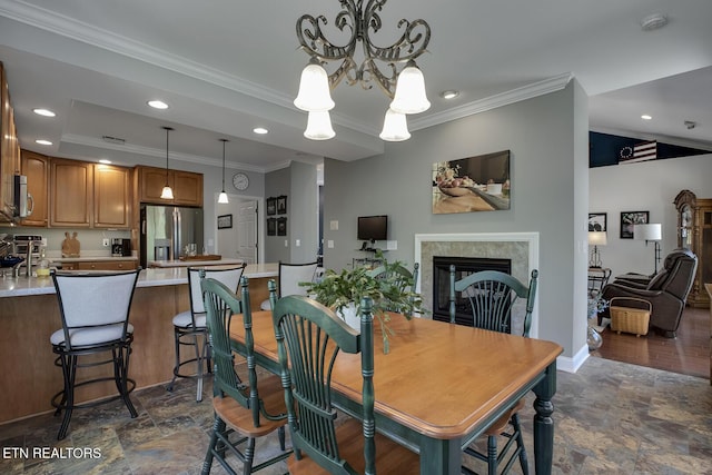 405 Tecumseh Pt, Loudon, TN 37774 - dining room with a fireplace, stone finish flooring, crown molding, and a notable chandelier