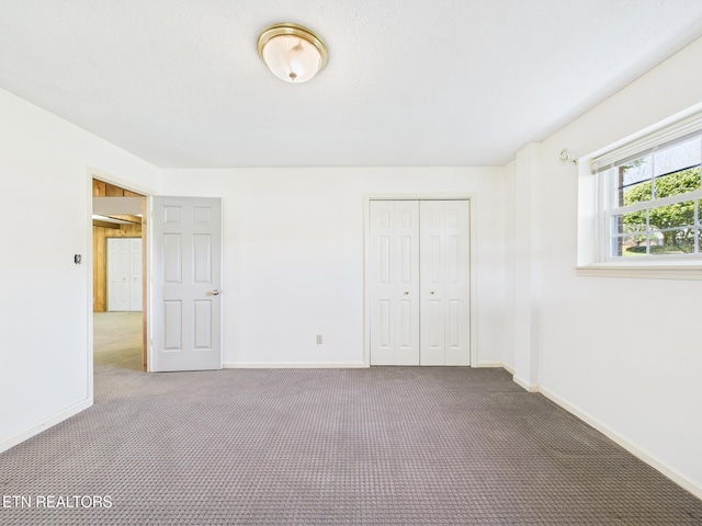 unfurnished bedroom featuring a closet, carpet flooring, and baseboards
