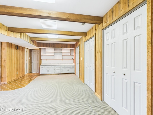 basement featuring light colored carpet and wooden walls