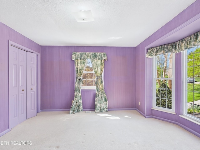 unfurnished bedroom with baseboards, carpet, and a textured ceiling