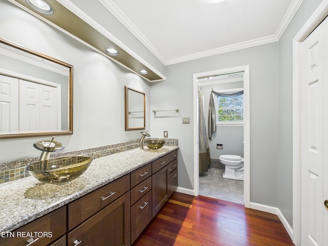 full bathroom featuring toilet, wood finished floors, a sink, and baseboards