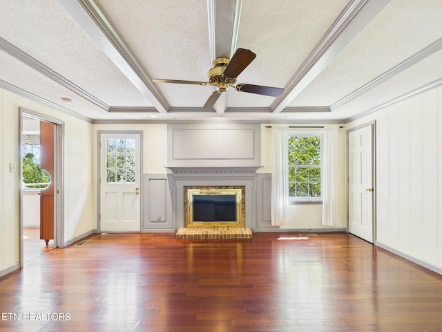 unfurnished living room with ornamental molding, a fireplace, ceiling fan, a decorative wall, and wood finished floors
