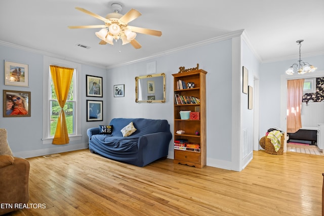 207 Loomis St, Tellico Plains, TN 37385 - living room with light wood finished floors, visible vents, ceiling fan with notable chandelier, and crown molding