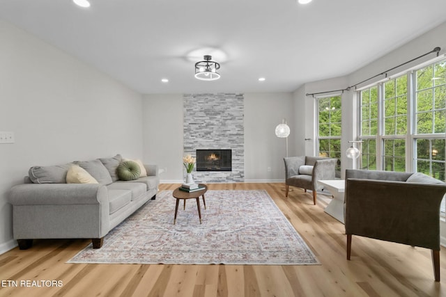 living room with baseboards, recessed lighting, wood finished floors, and a fireplace