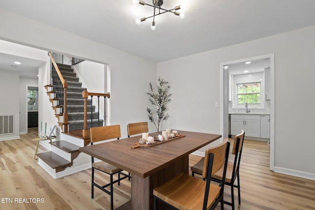 dining space with stairs, visible vents, light wood-type flooring, and baseboards