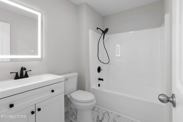 bathroom featuring toilet, marble finish floor, shower / washtub combination, and vanity