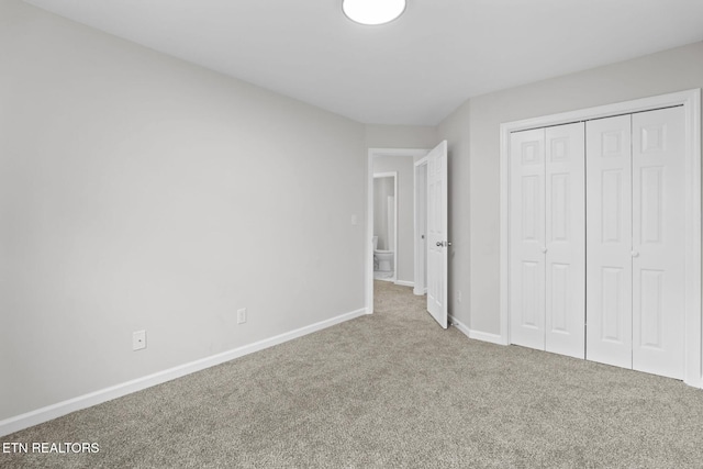 unfurnished bedroom featuring a closet, baseboards, and carpet
