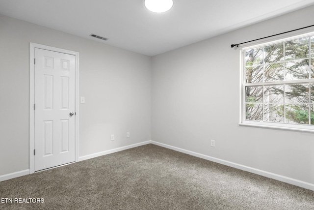 carpeted empty room featuring visible vents and baseboards