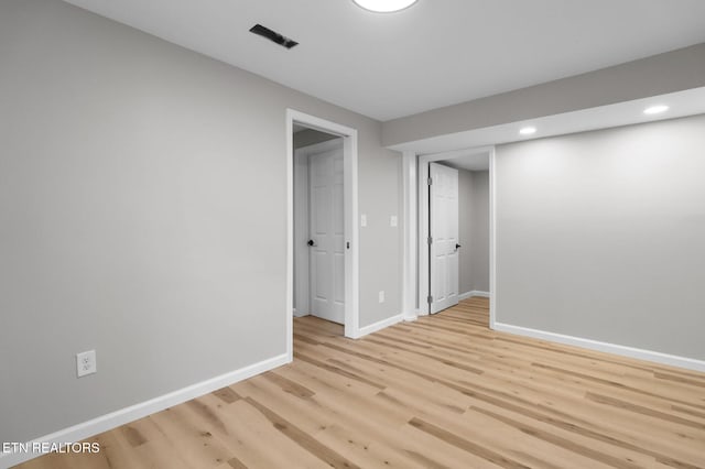 unfurnished room with recessed lighting, light wood-type flooring, visible vents, and baseboards