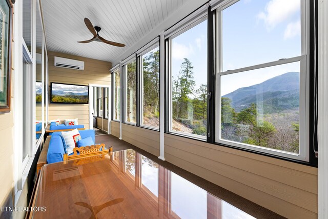 sunroom with a ceiling fan, healthy amount of natural light, and a wall mounted air conditioner