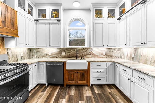 kitchen featuring stainless steel appliances, a sink, white cabinetry, and backsplash
