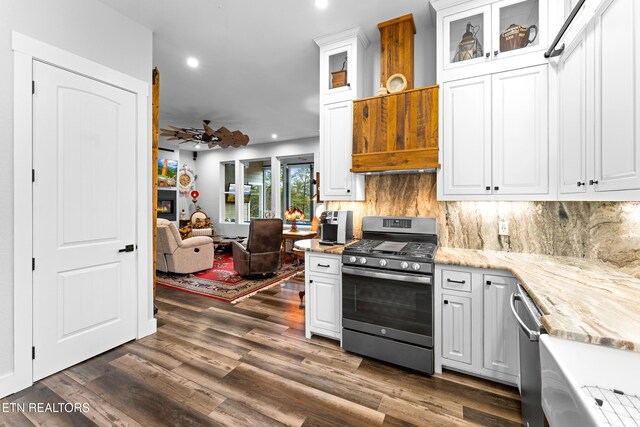 kitchen with stainless steel appliances, a ceiling fan, white cabinetry, tasteful backsplash, and light stone counters