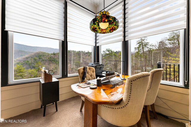 sunroom with carpet floors and a mountain view