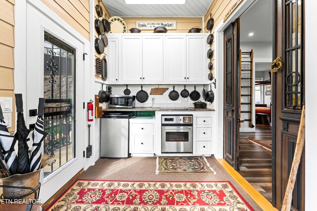 kitchen featuring appliances with stainless steel finishes, white cabinetry, wood finished floors, and light countertops
