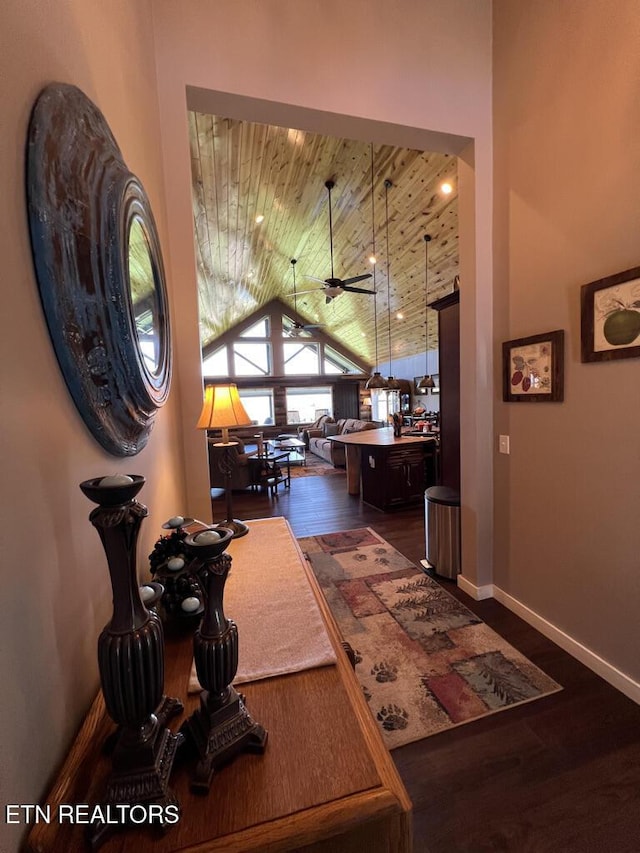 hallway with dark wood-type flooring, baseboards, lofted ceiling, and wooden ceiling