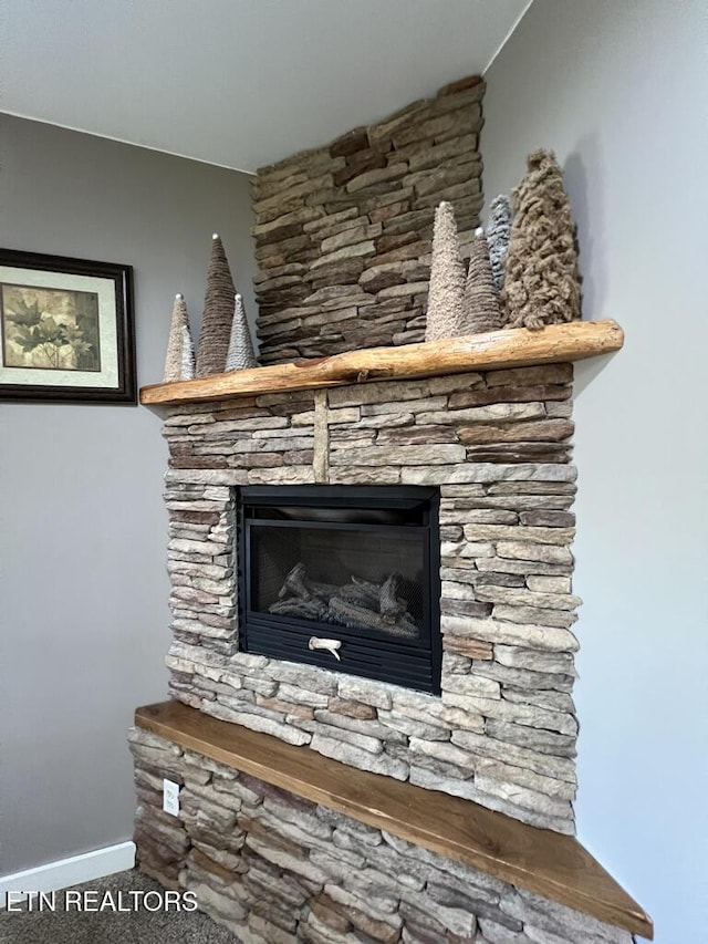 details featuring carpet floors, baseboards, and a fireplace