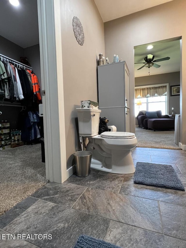 bathroom with baseboards, ceiling fan, and toilet