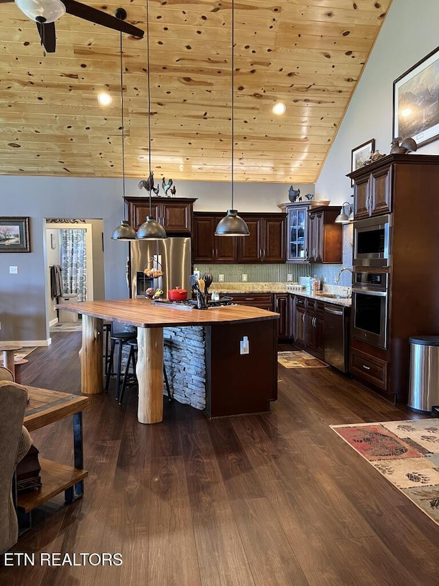 kitchen featuring dark brown cabinetry, a kitchen island, butcher block countertops, wooden ceiling, and appliances with stainless steel finishes