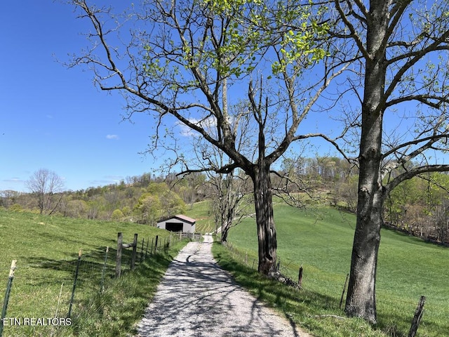 view of home's community with a lawn, fence, and an outbuilding