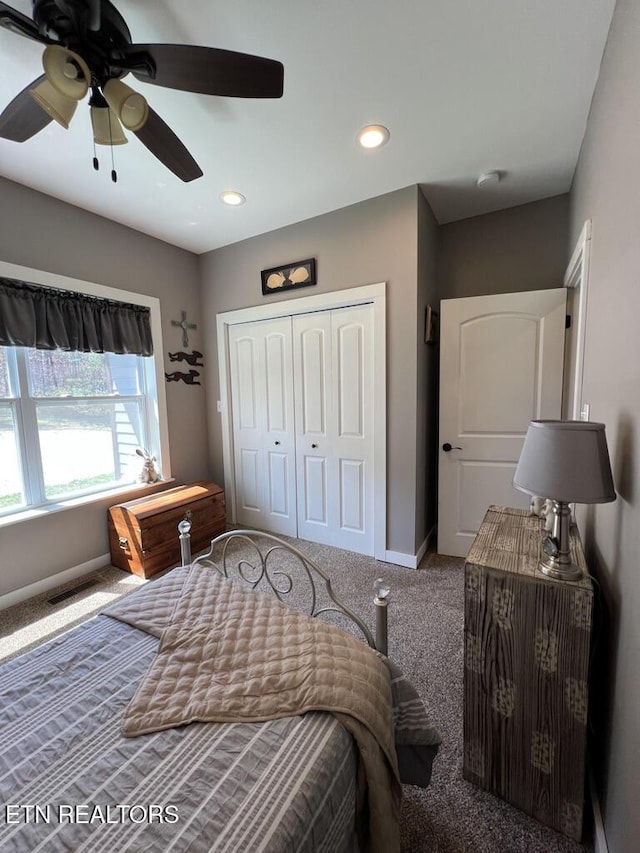 carpeted bedroom featuring baseboards, visible vents, ceiling fan, and a closet