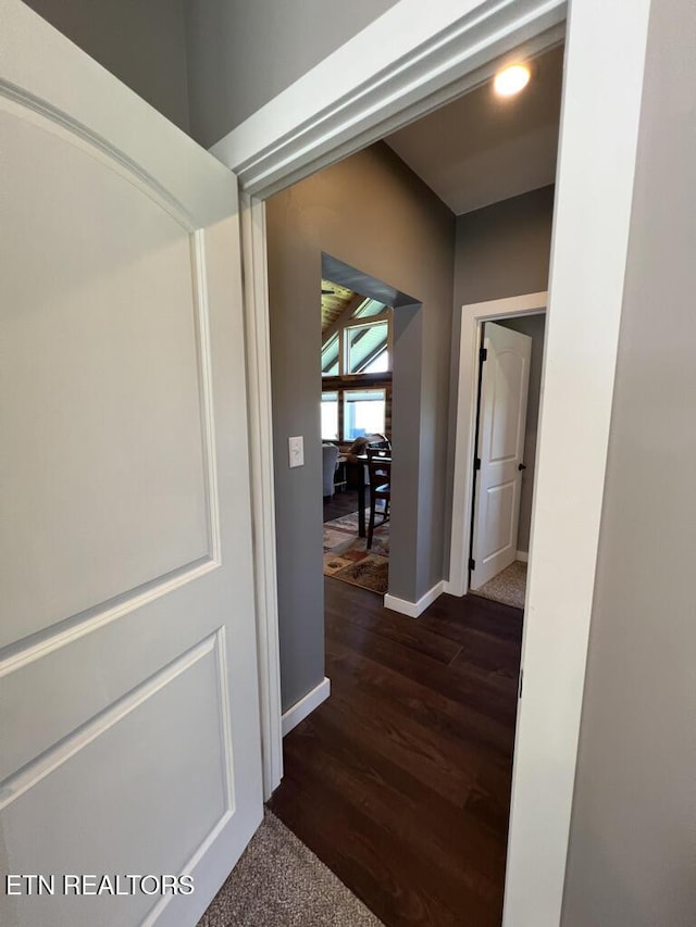 hall featuring baseboards and dark wood finished floors