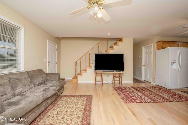 211 Peanut Ln, New Tazewell, TN 37825 - living room with light wood-style floors, ceiling fan, baseboards, and stairs