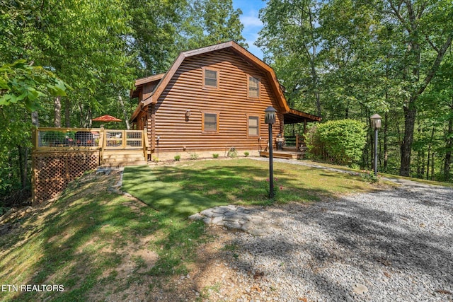 view of property exterior with log exterior, a gambrel roof, and a lawn