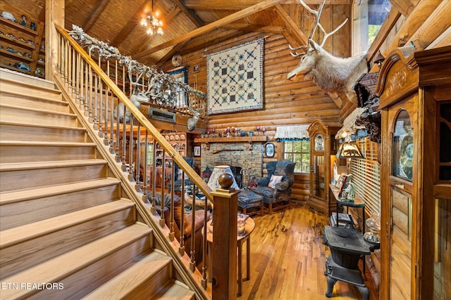 stairs featuring high vaulted ceiling, an inviting chandelier, rustic walls, wood ceiling, and wood-type flooring