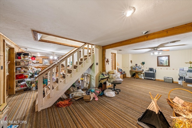interior space featuring stairway, ceiling fan, a textured ceiling, and carpet floors