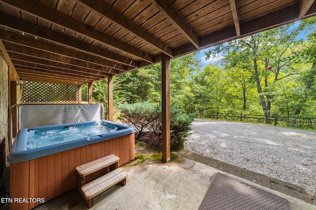 view of patio featuring fence and a hot tub