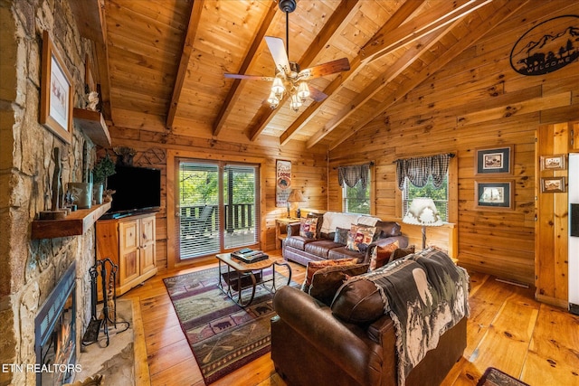 living room with wood walls, light wood-style flooring, vaulted ceiling with beams, and wood ceiling
