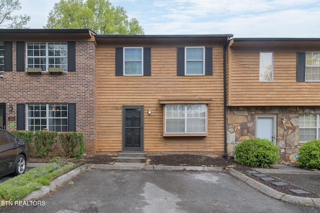 townhome / multi-family property with entry steps and stone siding
