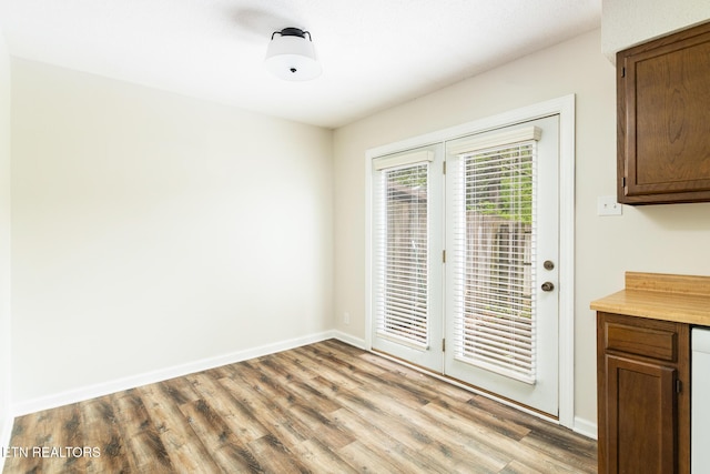 unfurnished dining area featuring light wood-style floors and baseboards