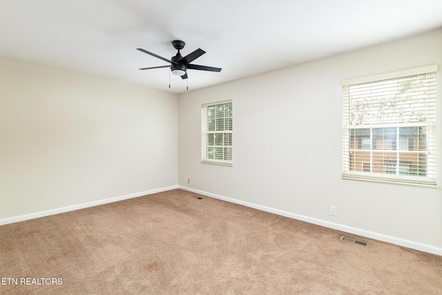 empty room with visible vents, ceiling fan, baseboards, and carpet