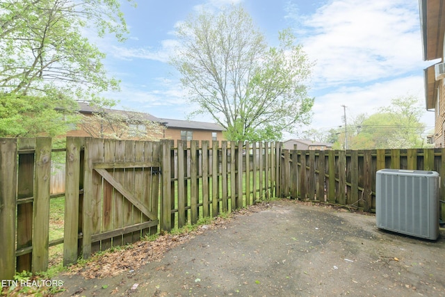view of patio / terrace with central AC, fence, and a gate