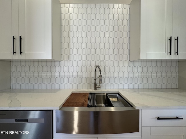 304 Broad St, Sweetwater, TN 37874 - kitchen featuring stainless steel dishwasher, white cabinetry, backsplash, and light stone counters