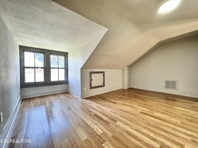 304 Broad St, Sweetwater, TN 37874 - additional living space with a textured ceiling, vaulted ceiling, visible vents, wood finished floors, and baseboards