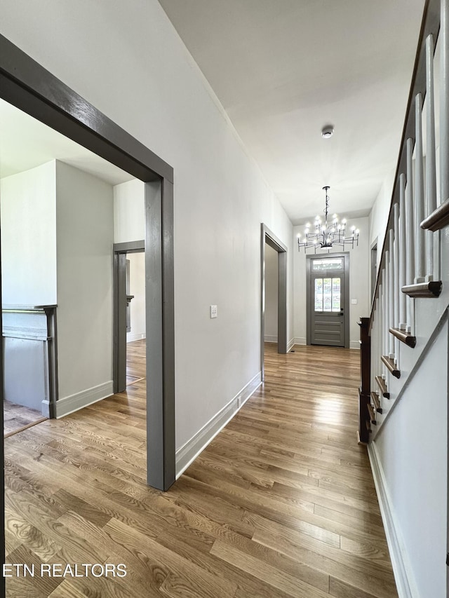 304 Broad St, Sweetwater, TN 37874 - hall with baseboards, stairway, a notable chandelier, and wood finished floors